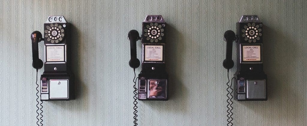 3 rotary dial phones mounted on the wall
