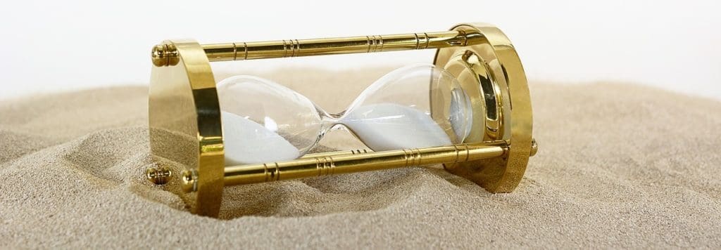 Hourglass, time, on its side in the sand